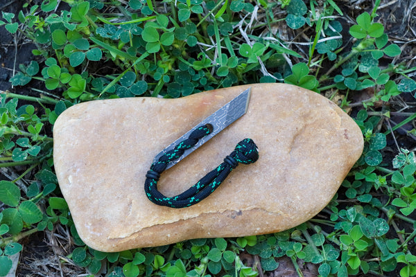 Banzelcroft Customs Nano kiridashi, a small fixed blade for everyday cutting tasks made from reptillian damascus and black paracord.