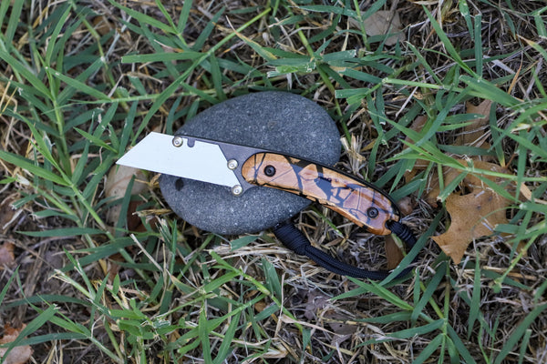 Banzelcroft Customs MEK, a custom titanium EDC utility knife with crosscut mammoth tusk handle scales and black liners.