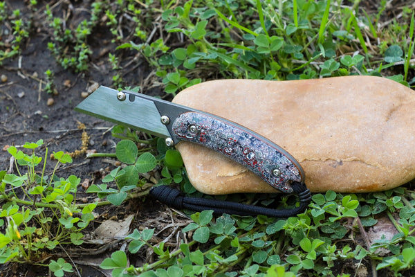 Banzelcroft Customs MEK, a titanium EDC utility knife with fordite scales and vintage natural canvas micarta liners.