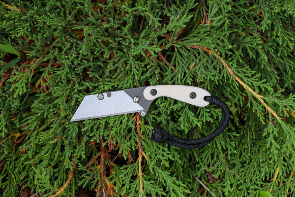 Banzelcroft Customs MEK, a custom titanium EDC utility knife with ivory linen micarta handle scales.