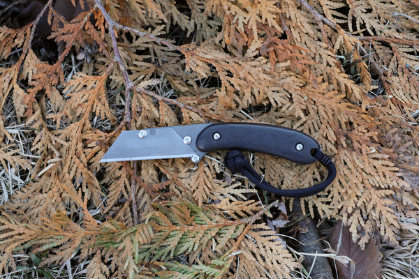 Banzelcroft Customs MEK, a custom titanium EDC utility knife with marbled carbon fiber handle scales.