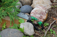 Banzelcroft Customs MEK, a custom titanium EDC utility knife with cast pinecone handle scales and linen micarta liners.