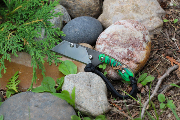 Banzelcroft Customs MEK, a custom titanium EDC utility knife with cast pinecone handle scales and linen micarta liners.