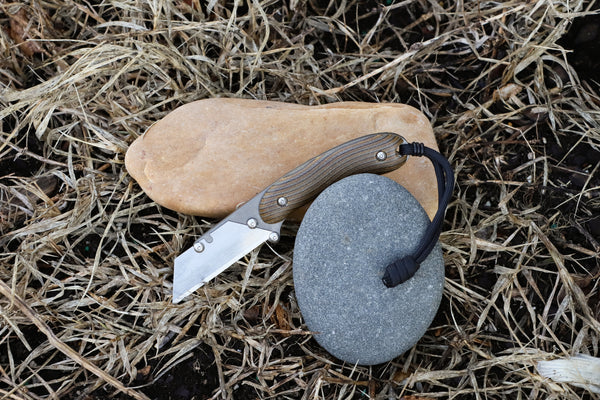 Banzelcroft Customs MEK, a titanium EDC utility knife with brown quad ripple micarta handle scales.