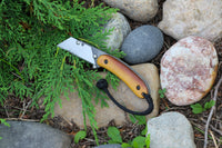 Banzelcroft Customs MEK, a custom titanium EDC utility knife with vintage Westinghouse butterscotch linen micarta handle scales and a black and white double liner.