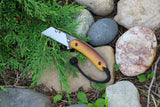 Banzelcroft Customs MEK, a custom titanium EDC utility knife with vintage Westinghouse butterscotch linen micarta handle scales and a black and white double liner.