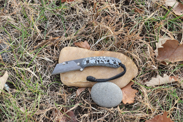 Banzelcroft Customs MEK, a titanium EDC utility knife with black and grey G10 handle scales.
