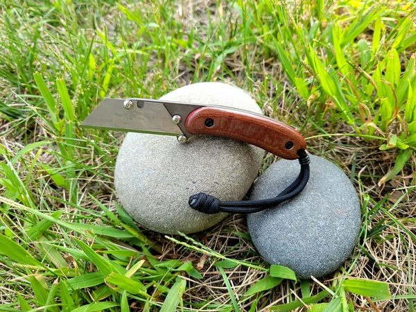 Banzelcroft Customs MEK, a custom titanium EDC utility knife with natural canvas micarta handle scales and carbon fiber and red liners.