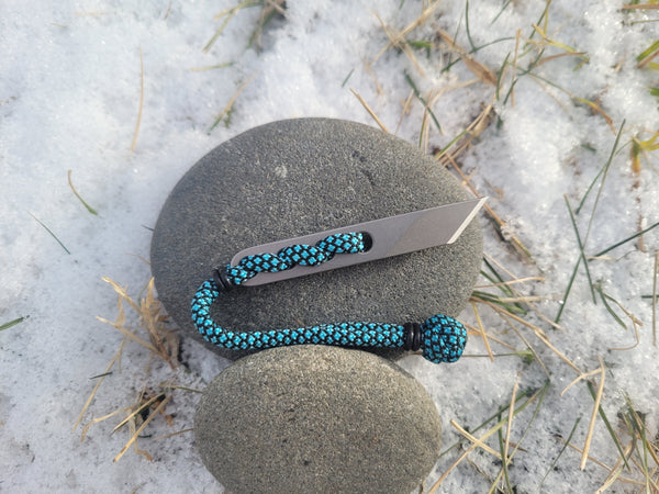 Banzelcroft Customs Nano kiridashi, a small fixed blade for evryday cutting tasks made from magnacut steel and turquoise diamond paracord.